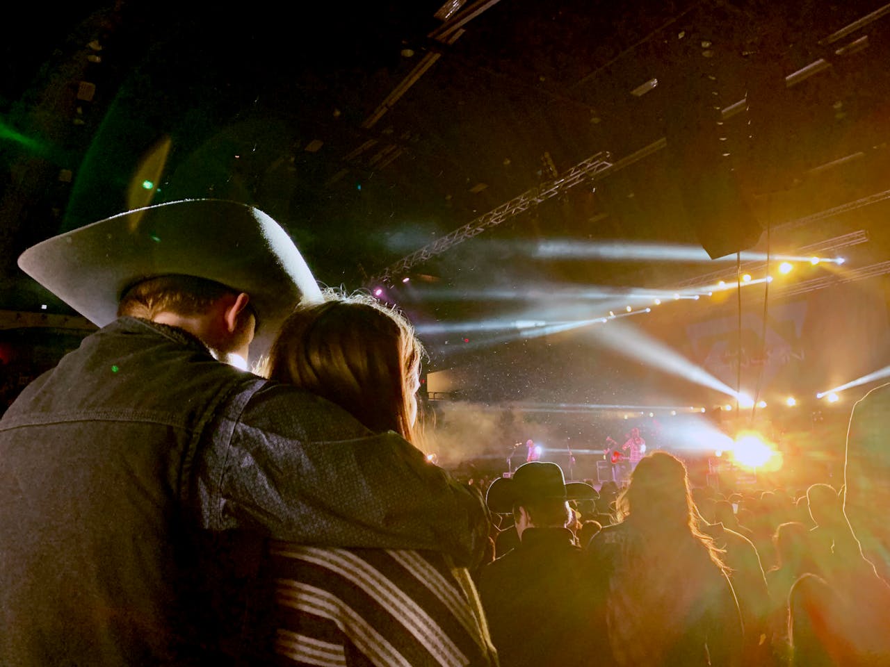 services-05 Couple enjoying a vibrant live country concert under bright stage lights.
