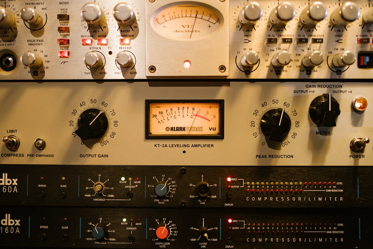 why-choose-us Close-up of audio amplifiers and compressors in a music studio setup.
